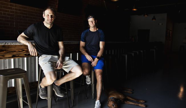 This Friday, April 30, 2021 photo shows from left, Bates and Anthony Battaglia in Raleigh, N.C.  The brothers are opening a new Glenwood South sports bar, Teets, named after their grandfather. (Juli Leonard/The News &amp;amp; Observer via AP)