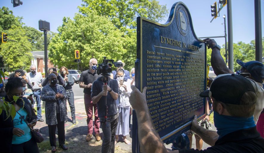 People gather to watch the installation of a historical marker that tells the story of the lynching of Porter Flournoy Turner in Atlanta&#x27;s Druid Hills community, Thursday, May 6, 2021. Porter Turner was lynched near the area in August 1945. (Alyssa Pointer/Atlanta Journal-Constitution via AP)