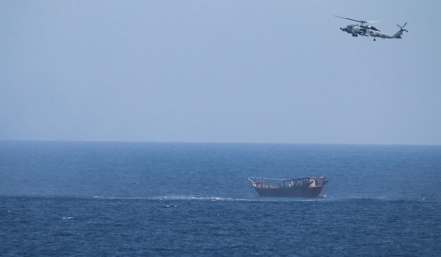 A U.S. Navy Seahawk helicopter flies over a stateless dhow later found to be carrying a hidden arms shipment in the Arabian Sea on Thursday, May 6, 2021. The U.S. Navy announced Sunday it seized the arms shipment hidden aboard the vessel in the Arabian Sea, the latest-such interdiction by sailors amid the long-running war in Yemen. (U.S. Navy via AP)