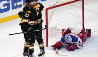 Boston Bruins left wing Nick Ritchie (21) is congratulated by Jake DeBrusk after his goal against New York Rangers goaltender Keith Kinkaid during the second period of an NHL hockey game, Saturday, May 8, 2021, in Boston. (AP Photo/Charles Krupa)