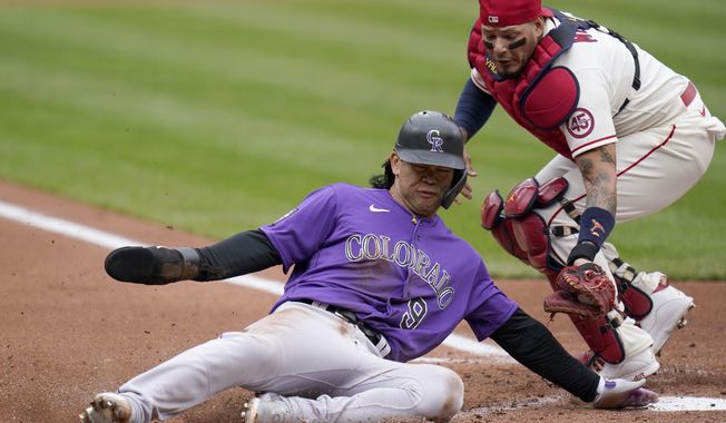 Colorado Rockies&#x27; Connor Joe (9) slides after being tagged out at home by St. Louis Cardinals catcher Yadier Molina during the second inning of a baseball game Saturday, May 8, 2021, in St. Louis. (AP Photo/Jeff Roberson)