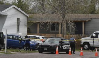 A Colorado Springs police officer goes to help a person who was in a different mobile home to be able to get to her car from behind the crime tape in Colorado Springs, Colo., Sunday, May 9, 2021. A gunman opened fire at a birthday party in Colorado, slaying six adults before killing himself Sunday. Police say the shooting happened just after midnight in a mobile home park on the east side of Colorado Springs. The Colorado Springs Gazette reports officers arrived at a trailer to find six dead adults and a man with serious injuries who died later at a hospital. (Jerilee Bennett/The Colorado Springs Gazette via AP)