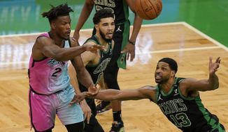 Miami Heat&#39;s Gabe Vincent, left, passes the ball as Boston Celtics&#39; Jayson Tatum, center, and Tristan Thompson, right, try to block in the first half of a basketball game, Sunday, May 9, 2021, in Boston. (AP Photo/Steven Senne)