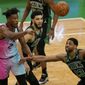 Miami Heat&#39;s Gabe Vincent, left, passes the ball as Boston Celtics&#39; Jayson Tatum, center, and Tristan Thompson, right, try to block in the first half of a basketball game, Sunday, May 9, 2021, in Boston. (AP Photo/Steven Senne)