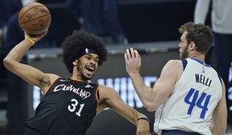 Cleveland Cavaliers&#39; Jarrett Allen (31) tries to pass the ball against Dallas Mavericks&#39; Nicolo Melli (44) in the first half of an NBA basketball game, Sunday, May 9, 2021, in Cleveland. (AP Photo/Tony Dejak)