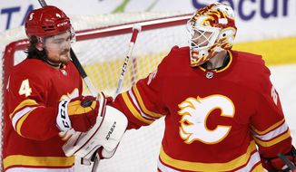 Calgary Flames goalie Jacob Markstrom, right, is congratulated by Rasmus Andersson after the team&#39;s 6-1 victory over the Ottawa Senators in an NHL hockey game Sunday, May 9, 2021, in Calgary, Alberta. (Larry MacDougal/The Canadian Press via AP)