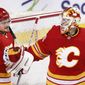 Calgary Flames goalie Jacob Markstrom, right, is congratulated by Rasmus Andersson after the team&#39;s 6-1 victory over the Ottawa Senators in an NHL hockey game Sunday, May 9, 2021, in Calgary, Alberta. (Larry MacDougal/The Canadian Press via AP)