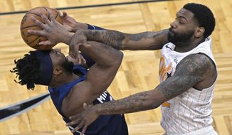 Minnesota Timberwolves forward Josh Okogie, left, is fouled by Orlando Magic guard Sindarius Thornwell while going up to shoot during the first half of an NBA basketball game, Sunday, May 9, 2021, in Orlando, Fla. (AP Photo/Phelan M. Ebenhack)