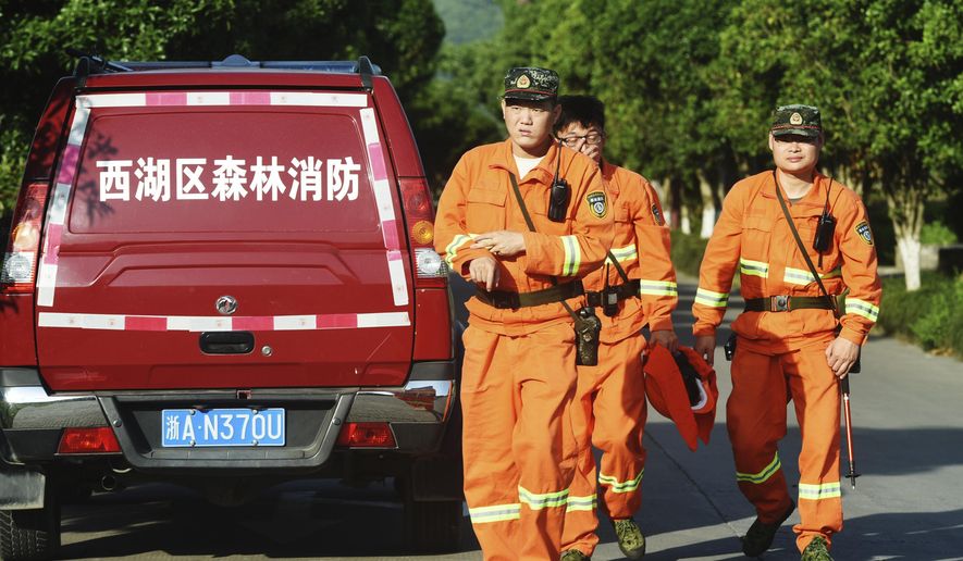 Workers take part in a search for a runaway leopard in Hangzhou in eastern China's Zhejiang province Sunday, May 9, 2021. A search for the last of three leopards that escaped from a safari park in eastern China was ongoing, authorities said Monday, May 10, 2021 as the park came under fire for concealing the breakout for nearly a week. (Chinatopix via AP)