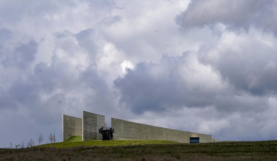 Visitors look from the observation platform at the Flight 93 National Memorial under a cloudy sky on Saturday, May 8, 2021, in Shanksville, Pa. (AP Photo/Keith Srakocic)