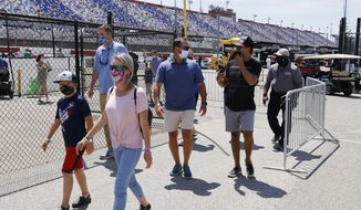 Fans walk through the garage area before a NASCAR Cup Series auto race at Darlington Raceway, Sunday, May 9, 2021, in Darlington, S.C. It is the first time this year that fans are allowed back in the garage area. (AP Photo/Terry Renna) **FILE**