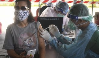 A health worker administers a dose of the AstraZeneca COVID-19 vaccine to a resident of the Klong Toey area, a neighborhood currently having a spike in coronavirus cases, in Bangkok, Thailand, Monday, May 10, 2021. The health authorities in Thailand said Monday they have confirmed the country’s first cases of the Indian variant of the coronavirus, in a Thai woman and her 4-year-old son who have been in state quarantine since arriving from Pakistan. (AP Photo/Vichan Poti)