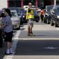A customer pumps gas at Costco, as a worker directs traffic, on Tuesday, May 11, 2021, in Charlotte, N.C. Colonial Pipeline, which delivers about 45% of the fuel consumed on the East Coast, halted operations last week after revealing a cyberattack that it said had affected some of its systems. (AP Photo/Chris Carlson)