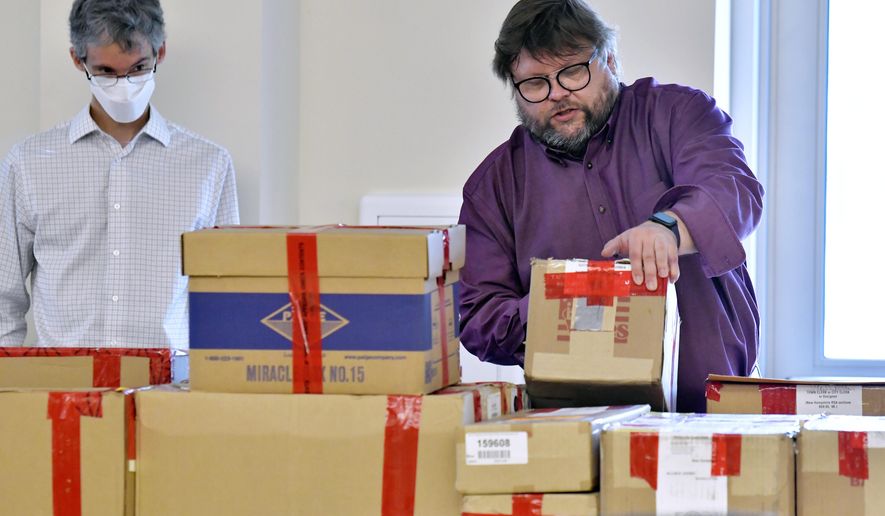 From left, election auditors Mark Lindeman, and Harri Hursti catalog ballot boxes Tuesday, May 11, 2021, in Pembroke, N.H., after they arrived at the site of a forensic audit of a New Hampshire legislative election. The audit, which will be live streamed from the Edward Cross Training Center, in Pembroke, is to review the November 2020 Windham, N.H., election for four state legislative seats. (AP Photo/Josh Reynolds)