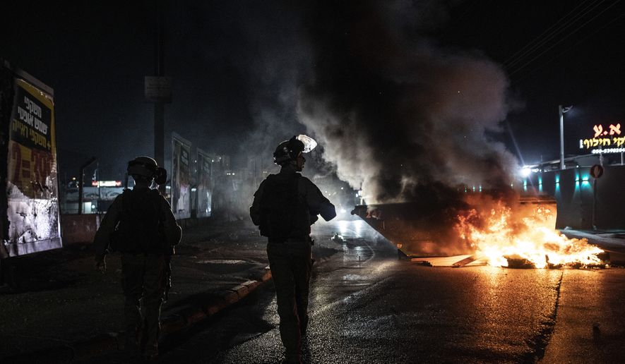 Israeli police patrol during clashes between Arabs, police and Jews, in the mixed town of Lod, central Israel, Wednesday, May 12, 2021. As rockets from Gaza streaked overhead, Arabs and Jews fought each other on the streets below. Rioters torched vehicles, a restaurant and a synagogue in one of the worst spasms of communal violence that Israel has seen in years. (AP Photo/Heidi Levine)