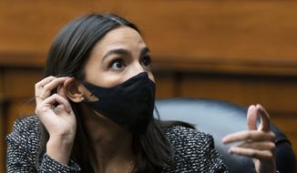 Rep. Alexandria Ocasio-Cortez, D-N.Y. talks to an aide during a House Committee on Oversight and Reform hearing on the Capitol breach on Capitol Hill, Wednesday, May 12, 2021, Washington. (AP Photo/Manuel Balce Ceneta) ** FILE **