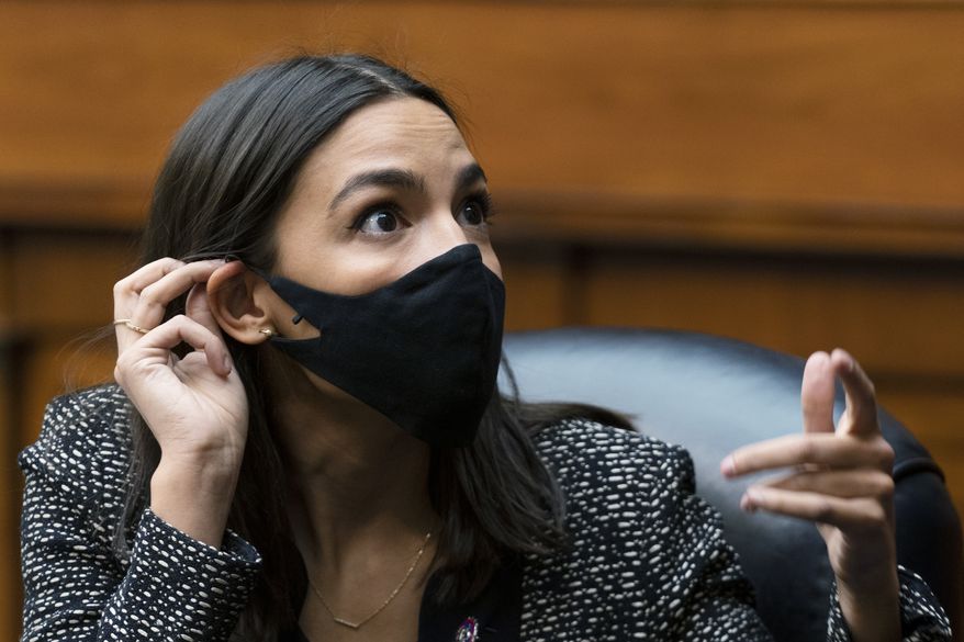 Rep. Alexandria Ocasio-Cortez, D-N.Y. talks to an aide during a House Committee on Oversight and Reform hearing on the Capitol breach on Capitol Hill, Wednesday, May 12, 2021, Washington. (AP Photo/Manuel Balce Ceneta) ** FILE **