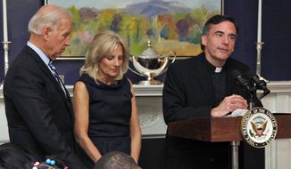 Vice President Joe Biden, left, and his wife, Jill Biden, center, stand with heads bowed as the Rev. Kevin O&#39;Brien says the blessing during a Thanksgiving meal for Wounded Warriors in Washington. AP Photo/Carolyn Kaster, File)