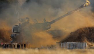 An Israeli artillery unit fires toward targets in Gaza Strip, at the Israeli Gaza border, Thursday, May 13, 2021. (AP Photo/Ariel Schalit)