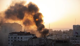 Smoke is seen from a collapsed building after it was hit by Israeli airstrikes on Gaza City, Wednesday, May 12, 2021. The Israeli airstrike was the latest in a series of assaults on targets in the Gaza Strip after a long dispute between Israel and Hamas erupted into an exchange of rocket attacks from Gaza and Israeli retaliation. (AP Photo/Khalil Hamra)