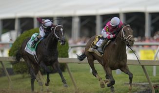 Flavien Prat atop Rombauer, right, looks back as he breaks away from Irad Ortiz Jr. atop Midnight Bourbon moments before crossing the finish line to win the Preakness Stakes horse race at Pimlico Race Course, Saturday, May 15, 2021, in Baltimore. (AP Photo/Julio Cortez)