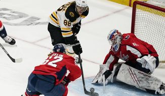 Boston Bruins right wing David Pastrnak (88) shoots but has his shot blocked by Washington Capitals goaltender Vitek Vanecek (41) during the first period of Game 1 of an NHL hockey Stanley Cup first-round playoff series Saturday, May 15, 2021, in Washington. (AP Photo/Alex Brandon)