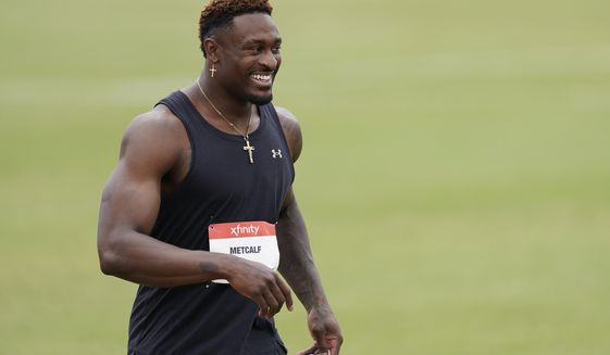 Seattle Seahawks wide receiver DK Metcalf smiles after competing in the second heat of the men&#39;s 100-meter dash prelim during the USATF Golden Games at Mt. San Antonio College Sunday, May 9, 2021, in Walnut, Calif. (AP Photo/Ashley Landis)