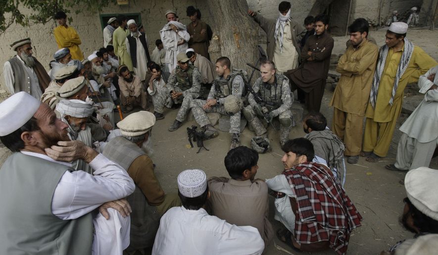 In this Nov. 3, 2009, file photo, Lt. Thomas Goodman, center, of the 2nd Battalion, 12th Infantry Regiment, 4th Brigade Combat Team, 4th Infantry Division meets with villagers in Qatar Kala in the Pech Valley of Afghanistan&#39;s Kunar province with his interpreter Ayazudin Hilal, center left with hat. Hilil served as an interpreter alongside U.S. soldiers on hundreds of patrols and dozens of firefights in eastern Afghanistan, earning a glowing letter of recommendation from an American platoon commander and a medal of commendation. Still, Hilal was turned down when he applied for one of the scarce special visas that would allow him to relocate to the U.S with his family. (AP Photo/David Guttenfelder, File)
