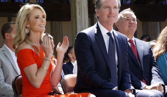 FILE-- In this July 1, 2019, file photo, First Partner Jennifer Siebel Newsom, left, attends a big signing ceremony with her husband, Gov. Gavin Newsom, right, at Sacramento City College in Sacramento, Calif. The Newsoms made about $500,000 more in 2019, Gavin Newsom&#39;s first year as governor, than they did before, according to tax returns released on May 17, 2021. Newsom, a Democrat, has pledged to release his returns every year. (AP Photo/Rich Pedroncelli, File)