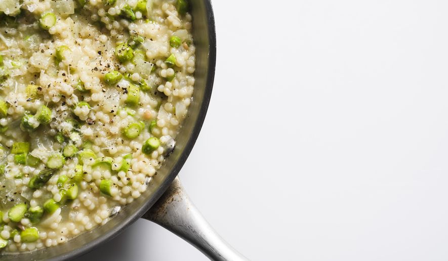 This image released by Milk Street shows a recipe for couscous risotto with asparagus. (Milk Street via AP)