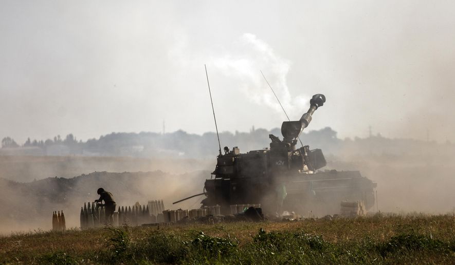 An Israeli artillery unit fires toward targets in the Gaza Strip, at the Israeli-Gaza border, Sunday, May 16, 2021. (AP Photo/Heidi Levine)