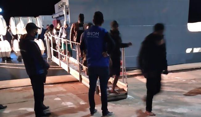 This photo provided by the International Organisation for Migration (IOM) Tunisia shows migrants disembarking in Tunisia, late Monday, May 17, 2021. Tunisian authorities say more than 50 migrants have drowned off the coast of the North African country, while 33 others were rescued by workers from an oil platform. (IOM Tunisia via AP)