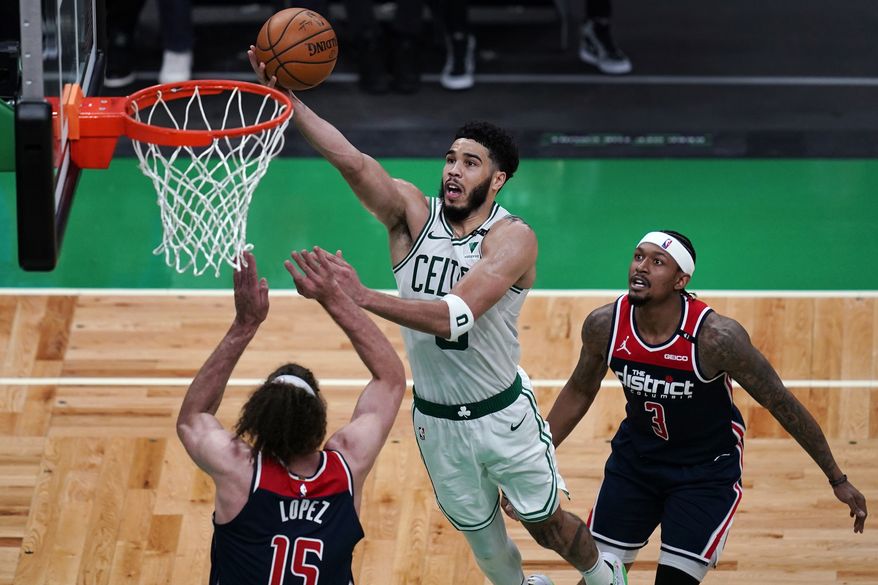 Boston Celtics forward Jayson Tatum drives to the basket against Washington Wizards center Robin Lopez (15) during the second half of an NBA basketball Eastern Conference play-in game Tuesday, May 18, 2021, in Boston. At right is Wizards guard Bradley Beal. (AP Photo/Charles Krupa)
