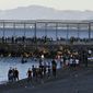 People from Morocco swim and walk into the Spanish territory at the border of Morocco and Spain, at the Spanish enclave of Ceuta on Monday, May 17, 2021. Authorities in Spain say that around 1,000 Moroccan migrants have crossed into Spanish territory (Antonio Sempere/Europa Press via AP)