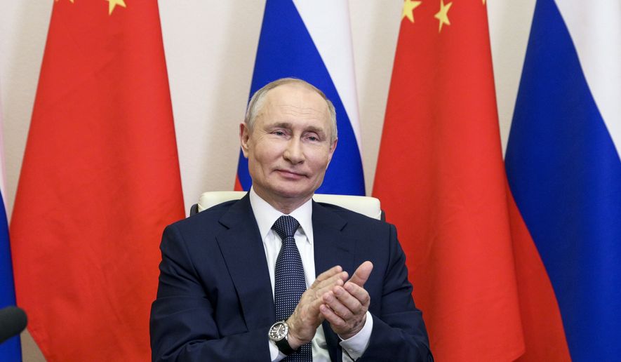 Russian President Vladimir Putin applauds as he takes part in a virtual unveiling of a nuclear power plant in China together with Chinese President Xi Jinping via video conference at the Novo-Ogaryovo residence outside Moscow, Russia, Wednesday, May 19, 2021. (Sergei Ilyin, Sputnik, Kremlin Pool Photo via AP)