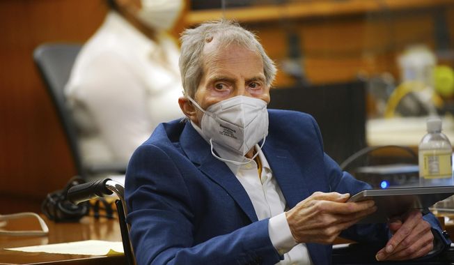 Robert Durst holds a device to read the real-time spoken script as he appears in the courtroom of Judge Mark E. Windham as attorneys begin opening statements in the trial of the real estate scion charged with murder of longtime friend Susan Berman, at Los Angeles County Superior Court, Tuesday, May 18, 2021, in Inglewood, Calif. Durst&#x27;s murder trial was delayed more than a year due to the COVID-19 pandemic. (Al Seib/Los Angeles Times via AP, Pool)