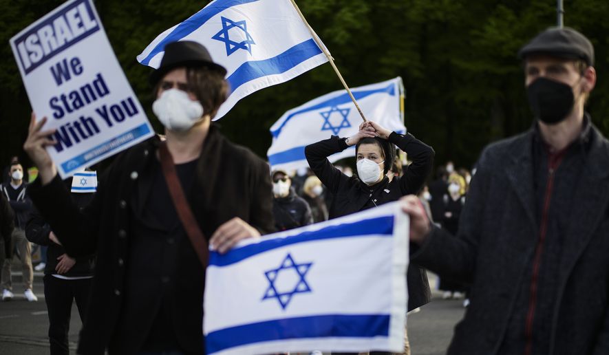 People with Israeli flags attend a rally in support of Israel, in Berlin, Germany, Thursday, May 20, 2021. (AP Photo/Markus Schreiber