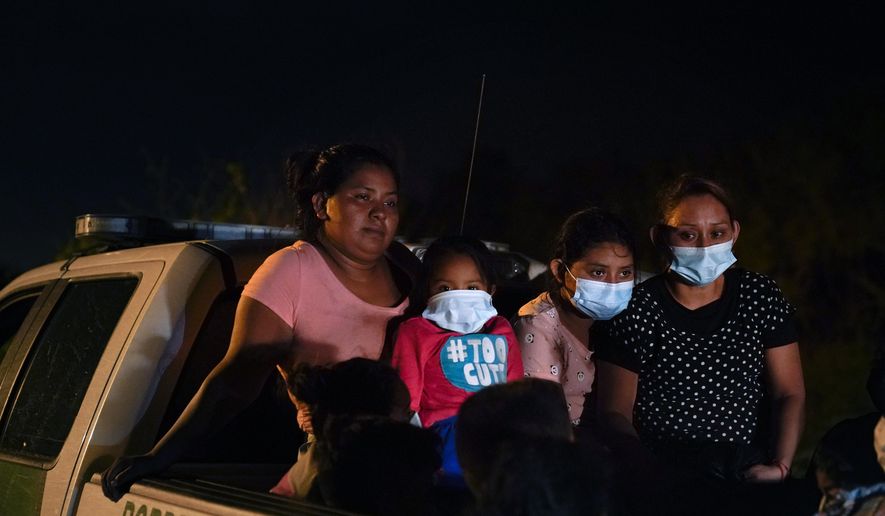 Migrants from Honduras wait in a Border Patrol truck after turning themselves in upon crossing the U.S.-Mexico border Monday, May 17, 2021, in La Joya, Texas. The Biden administration has agreed to let up to about 250 people a day in the United States at border crossings with Mexico to seek refuge, part of negotiations to settle a lawsuit over pandemic-related powers that deny migrants a right to apply for asylum, an attorney said Monday. (AP Photo/Gregory Bull)