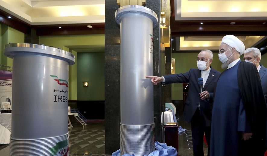 In this April 10, 2021 file photo released by the official website of the office of the Iranian Presidency, President Hassan Rouhani, second right, listens to the head of the Atomic Energy Organization of Iran Ali Akbar Salehi while visiting an exhibition of Iran&#x27;s new nuclear achievements in Tehran, Iran. (Iranian Presidency Office via AP, File)