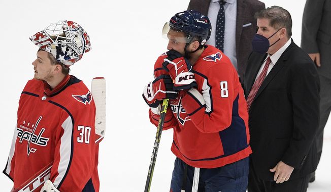 Washington Capitals left wing Alex Ovechkin (8), goaltender Ilya Samsonov (30) and head coach Peter Laviolette stand in the handshake line after Game 5 of an NHL hockey Stanley Cup first-round playoff series against the Boston Bruins, Sunday, May 23, 2021, in Washington. The Bruins won 3-1. (AP Photo/Nick Wass)