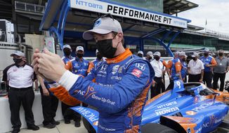 Scott Dixon, of New Zealand, takes a photo after winning the pole for the Indianapolis 500 auto race at Indianapolis Motor Speedway, Sunday, May 23, 2021, in Indianapolis. (AP Photo/Darron Cummings)
