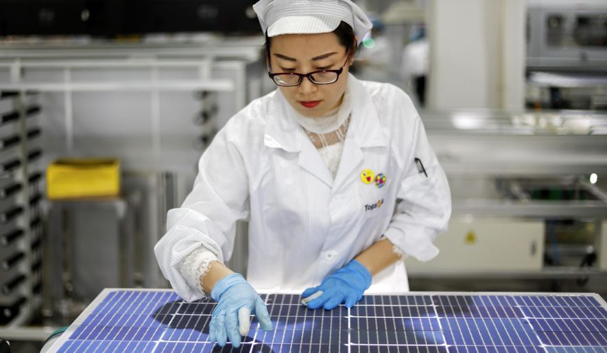 FILE - In this Jan. 5, 2021, file photo, an employee works at a solar panel and solar equipment factory in Jiujiang in central China&#39;s Jiangxi Province. The Biden administration’s solar power ambitions are colliding with complaints the global industry depends on Chinese raw materials that might be produced by forced labor. (Chinatopix via AP, File)