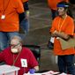 In this May 6, 2021 file photo, Maricopa County ballots cast in the 2020 general election are examined and recounted by contractors working for Florida-based company, Cyber Ninjas at Veterans Memorial Coliseum in Phoenix. (AP Photo/Matt York, Pool)  **FILE**