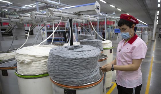 A worker watches as a machine processes cotton yarn at a Huafu Fashion plant, as seen during a government-organized trip for foreign journalists, in Aksu in western China&#39;s Xinjiang Uyghur Autonomous Region, Tuesday, April 20, 2021. A backlash against reports of forced labor and other abuses of the largely Muslim Uyghur ethnic group in Xinjiang is taking a toll on China&#39;s cotton industry, but it&#39;s unclear if the pressure will compel the government or companies to change their ways. (AP Photo/Mark Schiefelbein) ** FILE **