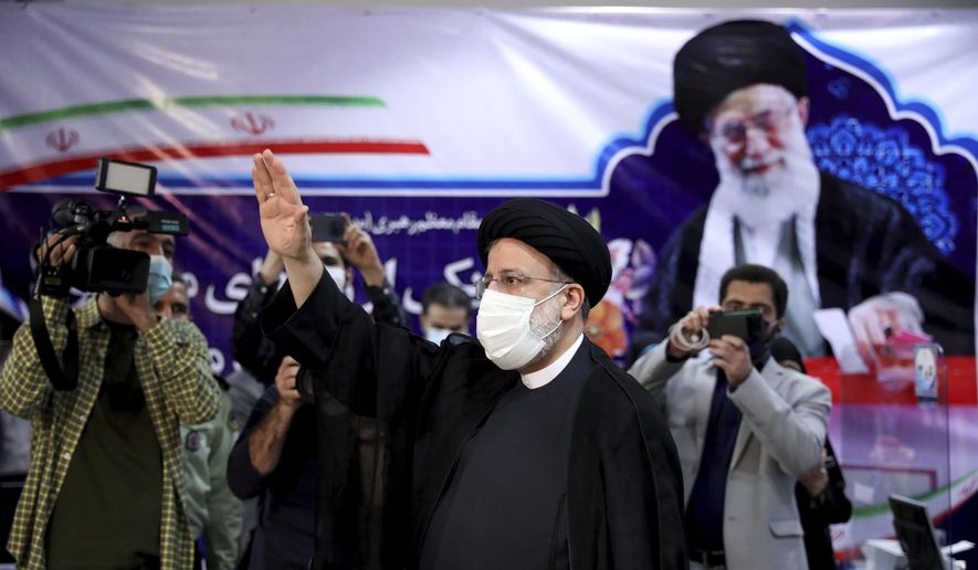 Ebrahim Raisi, head of Iran&#39;s judiciary waves to media as he attends at the Interior Ministry to register his candidacy for the June 18 presidential elections at the elections headquarters of the Interior Ministry in Tehran, Iran, Saturday, May 15, 2021. (AP Photo/Ebrahim Noroozi)