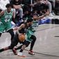 Brooklyn Nets guard Kyrie Irving, center, drives around Boston Celtics guard Marcus Smart (36) as Celtics center Robert Williams III (44) watches during the second quarter of Game 2 of an NBA basketball first-round playoff series Tuesday, May 25, 2021, in New York. (AP Photo/Kathy Willens)