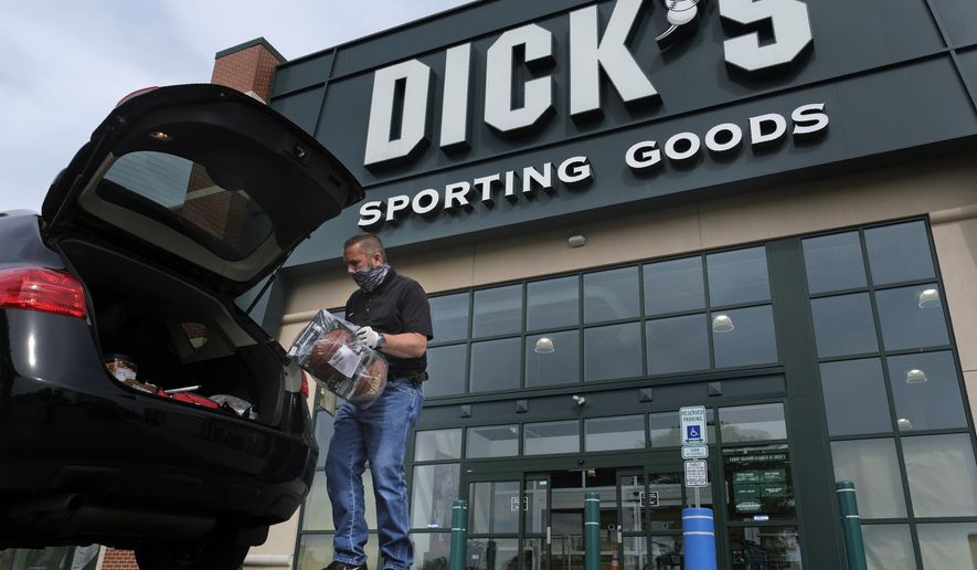 In this May 18, 2020 file photo, Gus Promollo delivers an order into a customer&#39;s trunk at Dick&#39;s Sporting Goods in Paramus, N.J. (AP Photo/Seth Wenig, File)