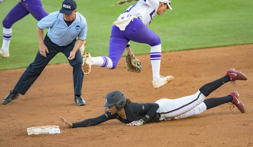 LSU infielder Taylor Pleasants (17) jumps to try and get the ball that sails past as Florida State infielder Kalei Harding (8) slides safely into second base during game one of the NCAA college softball super regional tournament on Thursday, May 27, 2021, in Baton Rouge, La. (AP Photo/Matthew Hinton)