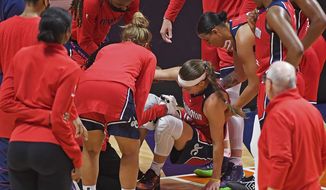 Washington Mystics players check on Sydney Wiese after she went down with an injury during the team&#x27;s WNBA basketball game against the Connecticut Sun Friday, May 28, 2021, in Uncasville, Conn. (Sean D. Elliot/The Day via AP)