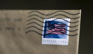 A stamp is shown on an envelope Friday, May 28, 2021, in Washington. The U.S. Postal Service is raising rates on first class stamps from 55 cents to 58 as part of a host of price hikes and service changes designed to reduce debt for the beleaguered agency. The changes, which will take effect on Aug. 29, include price hikes for first class mail, magazines and marketing mailers. (AP Photo/Jenny Kane)